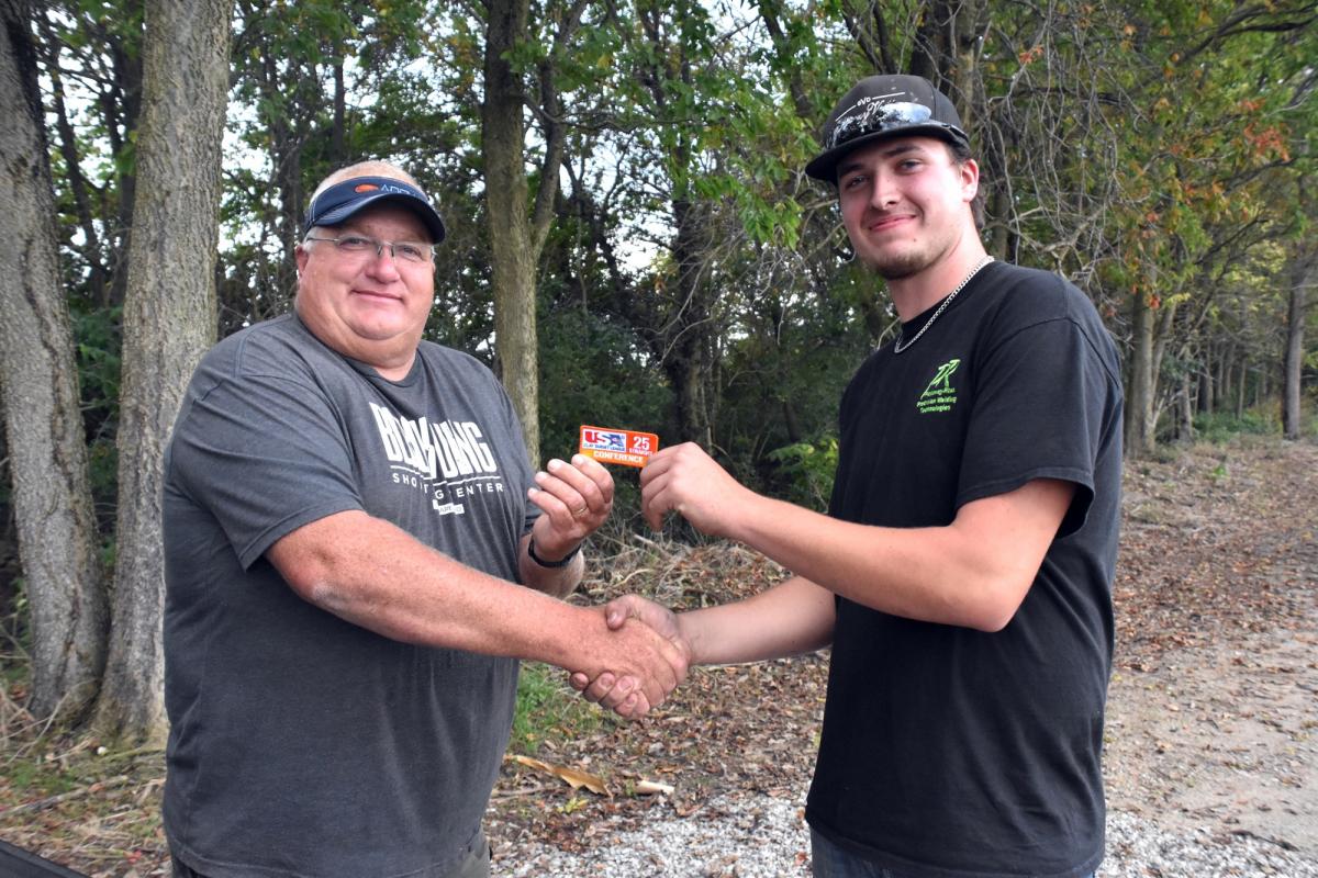 Coach Kirk Kellis presents a 25 Straight patch to his son, senior Lake Kellis.