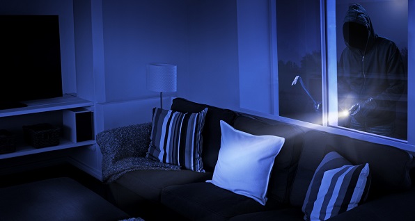 Burglar with flashlight attempts to gain access into house at night.