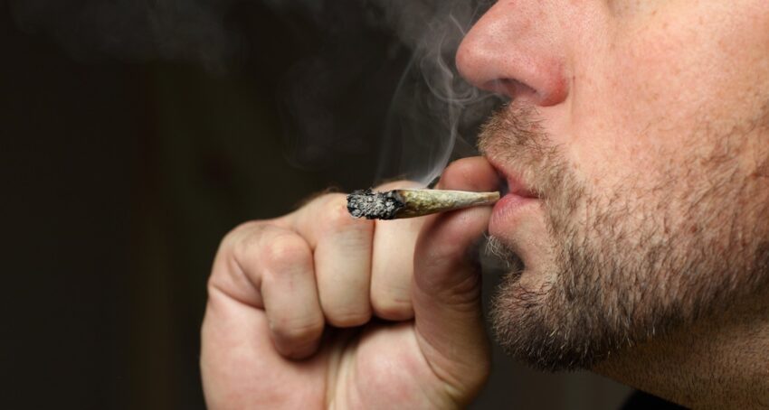 Close-up of a man smoking a marijuana joint